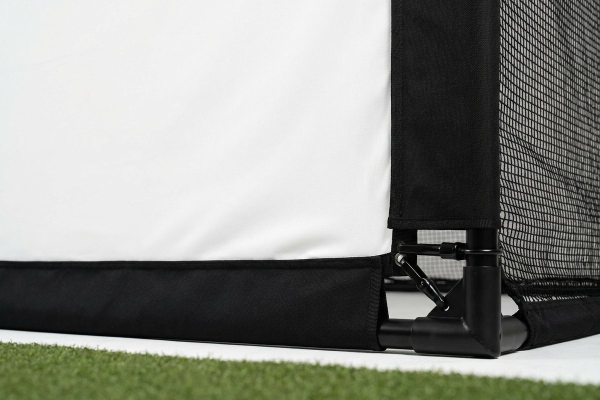 Detail view of a tensioned impact screen and enclosure frame with corner hardware and side barrier netting.